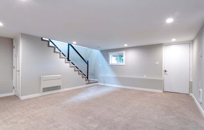 Spacious room with floor mounted air conditioning unit under stairway