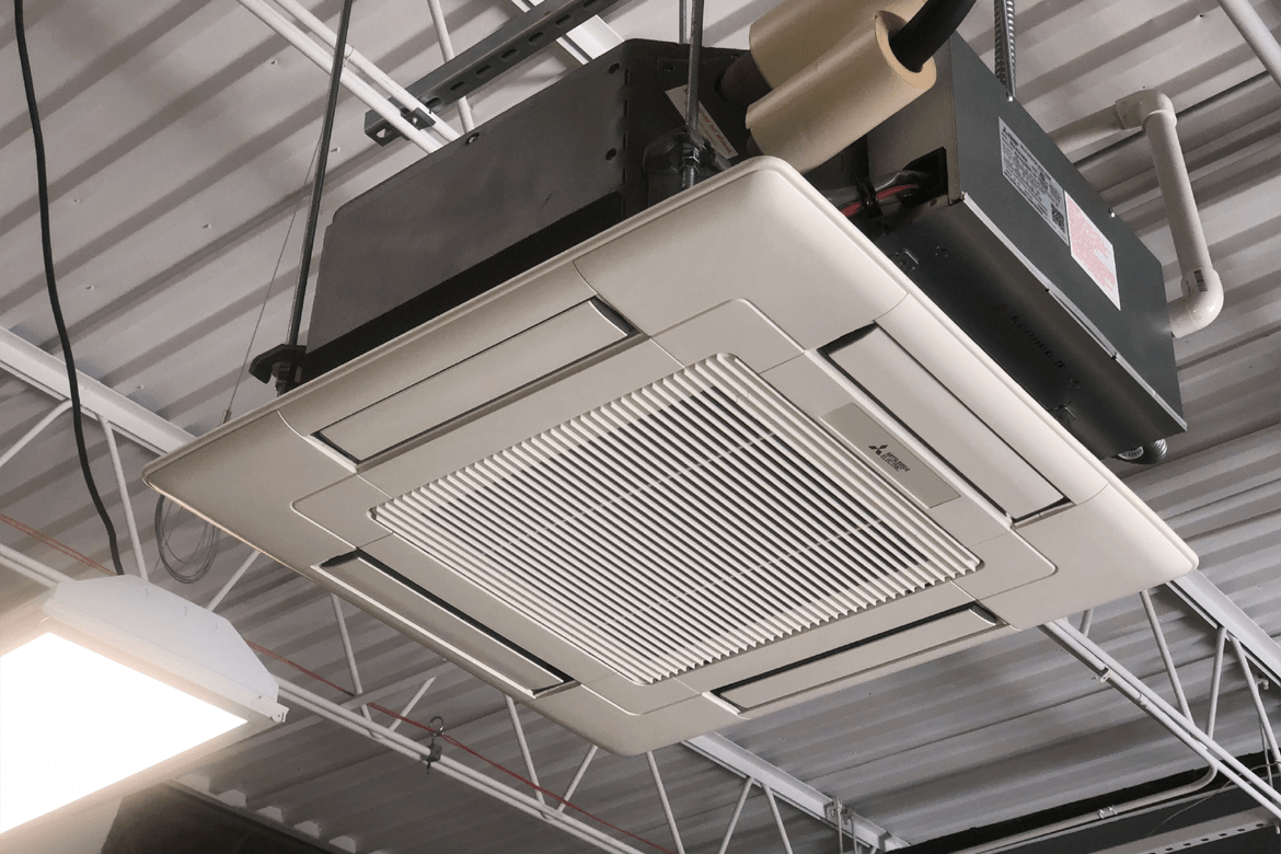 Ceiling-mounted cassette air conditioning unit with 360-degree airflow in a commercial space.