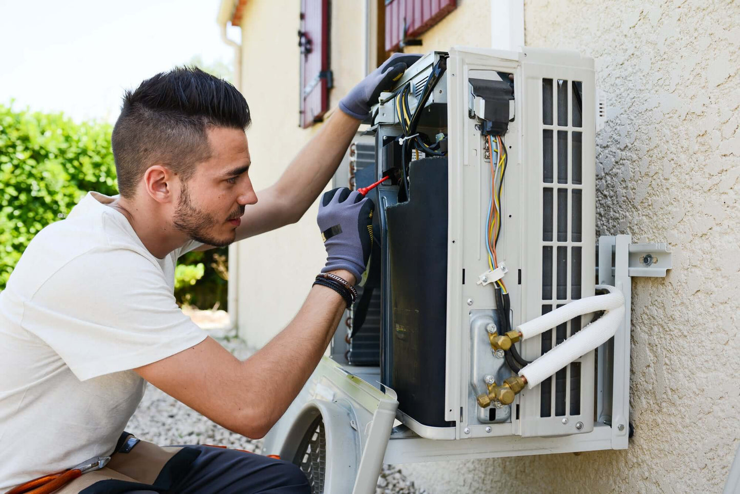 Technician repairing air conditioning unit during an emergency call out for air conditioning breakdowns.