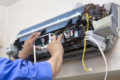 Technician repairing air conditioning unit during a breakdown, providing 24/7 emergency service for rapid and reliable repair.